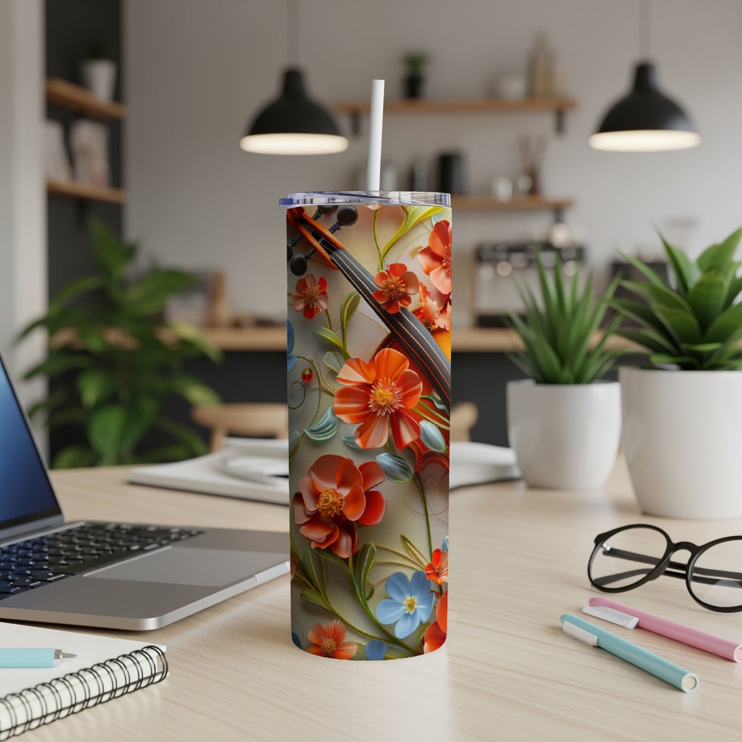 Floral pattern tumbler with straw on a desk with a laptop.
