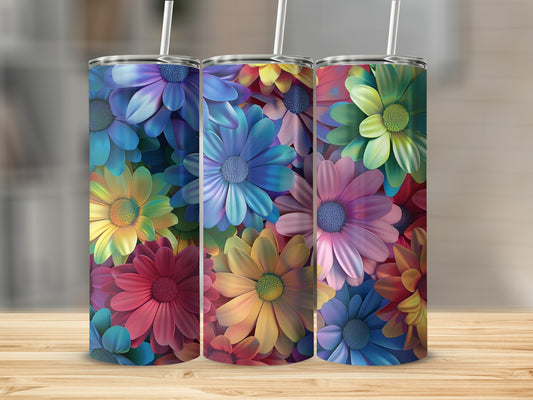 Three tumblers with colorful floral patterns sit on a wooden surface.