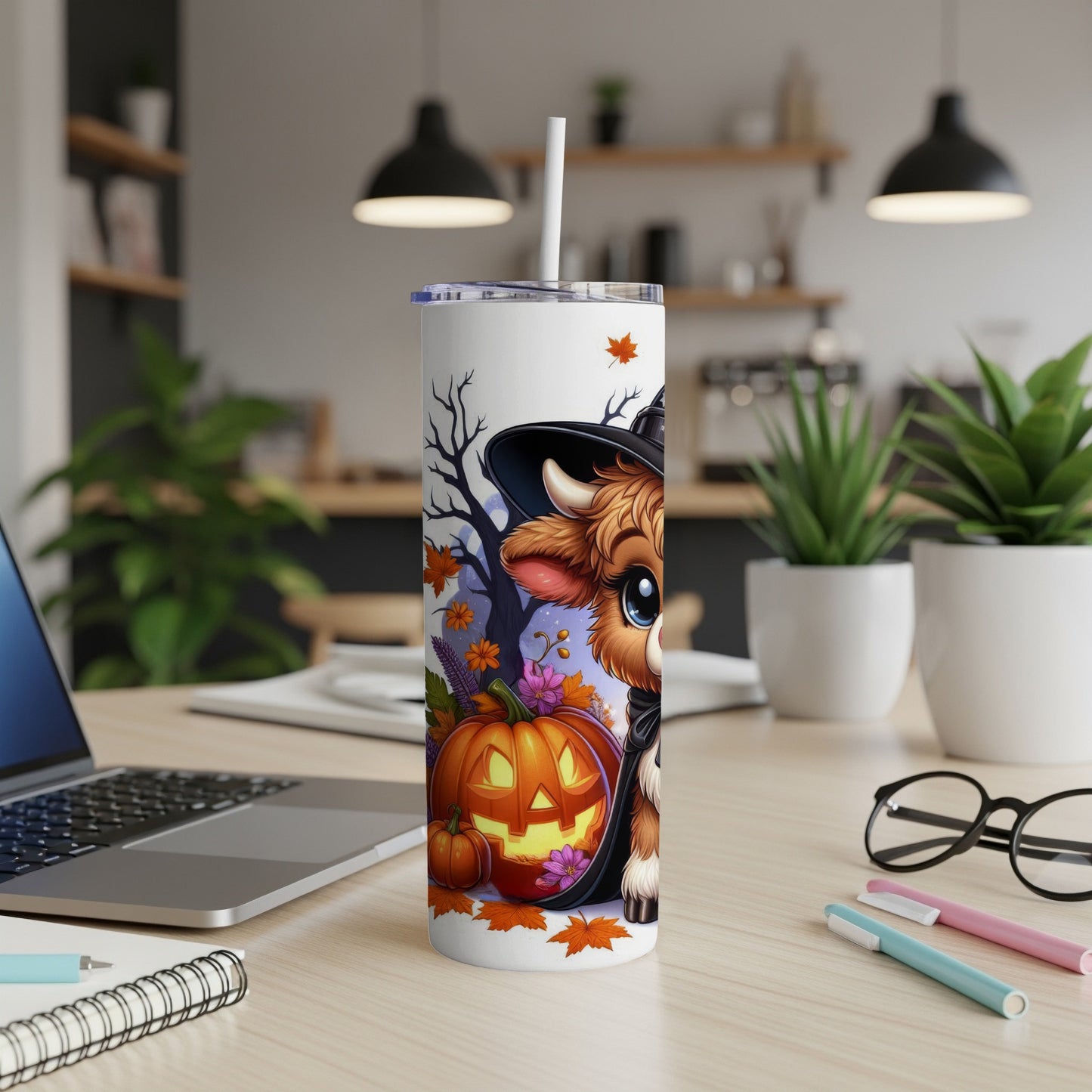 Cow in witch hat with pumpkins and fall leaves on a tumbler.
