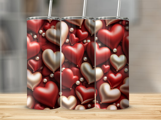 Three red and gold hearts with pearls, on a wooden surface.