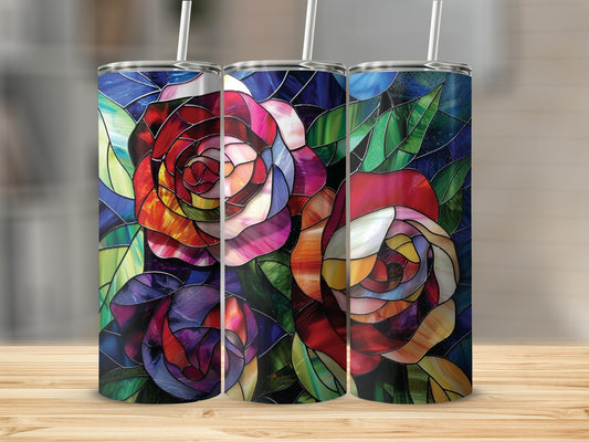 Three stained glass tumblers with rose and leaf designs on a wooden surface.