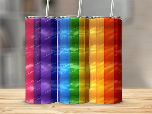 Three tall tumblers with rainbow stripe designs on a wooden surface.