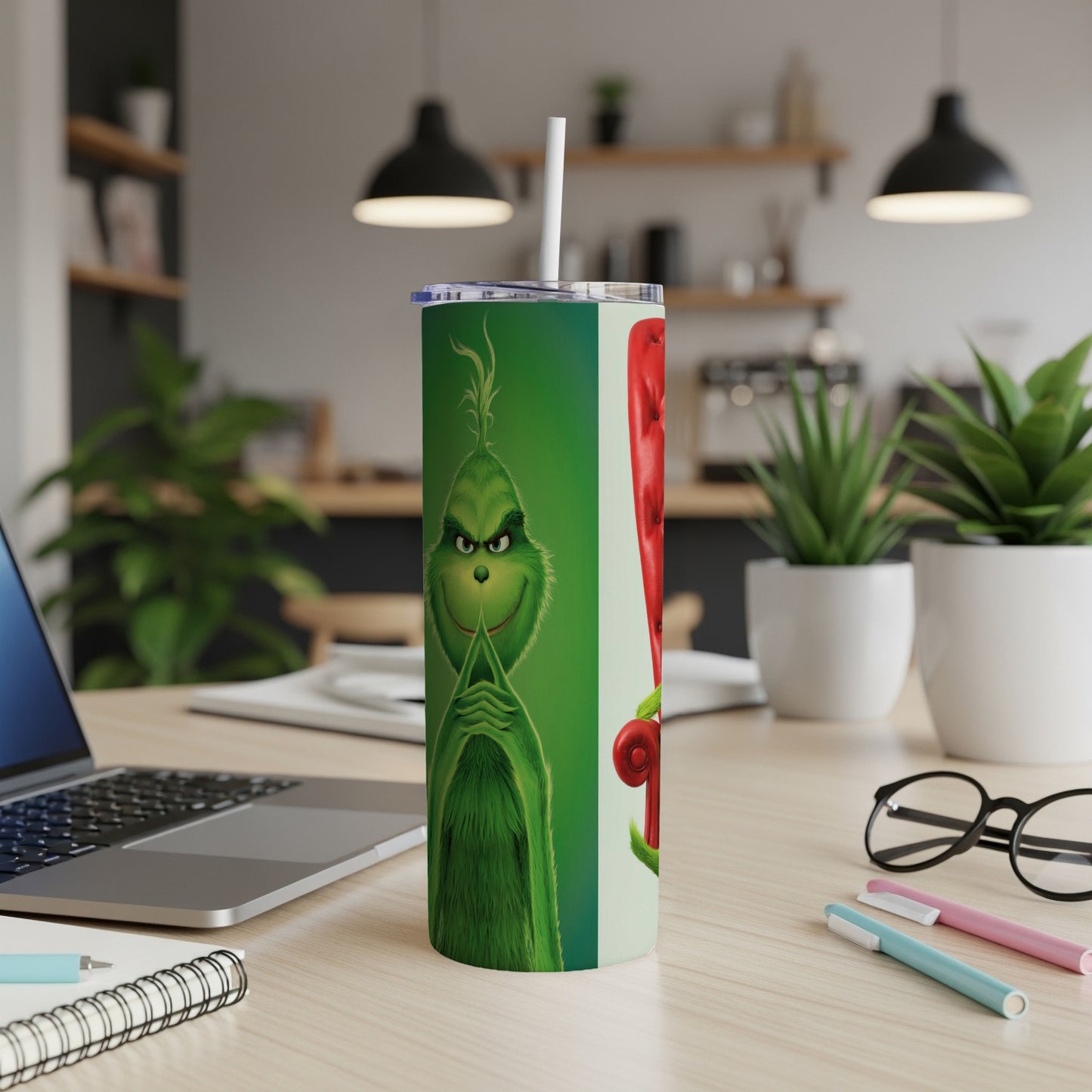 Green Grinch character on a tall tumbler with a straw.