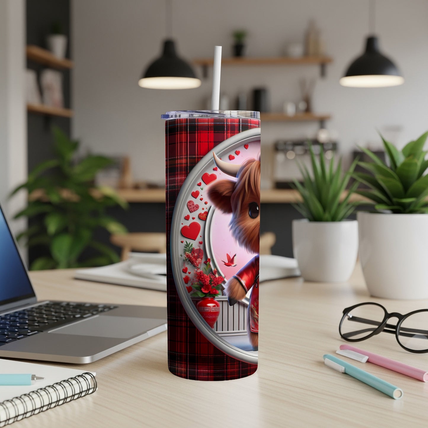 Highland cow illustration on plaid tumbler with hearts and floral accents.