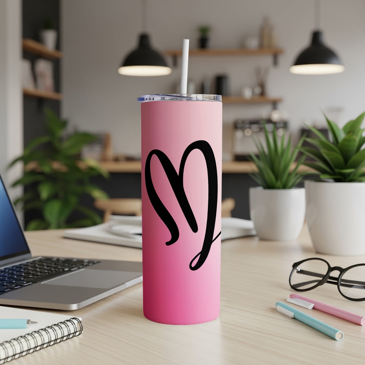 Pink tumbler with black heart graphic and white straw.