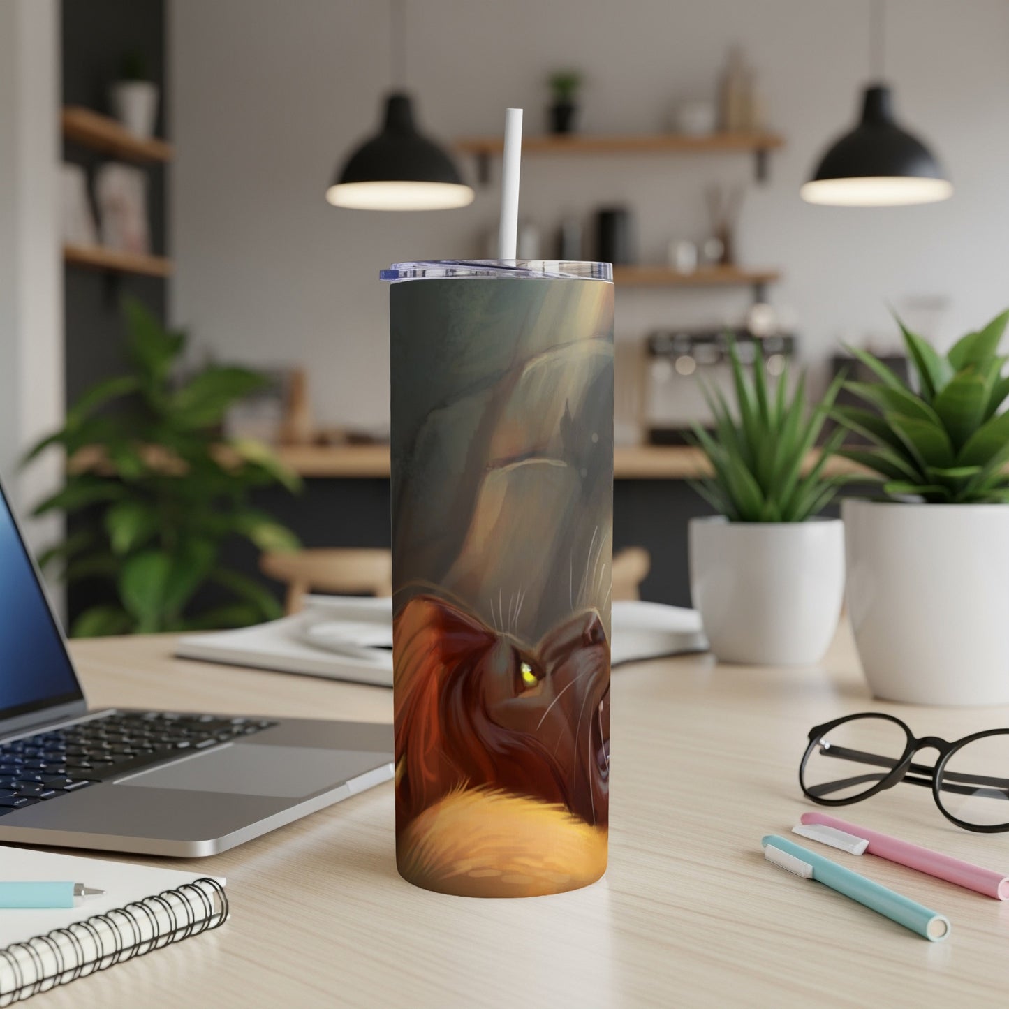Lion design on a white tumbler with a straw, on a desk.