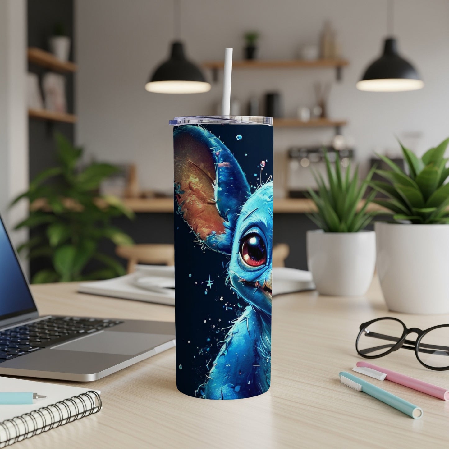 Blue alien character with large red eyes on a black speckled tumbler.