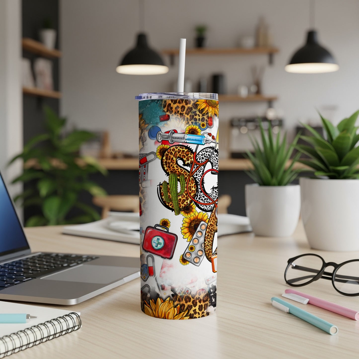 Tumbler with sunflowers, medical icons, and leopard print, standing on a desk.