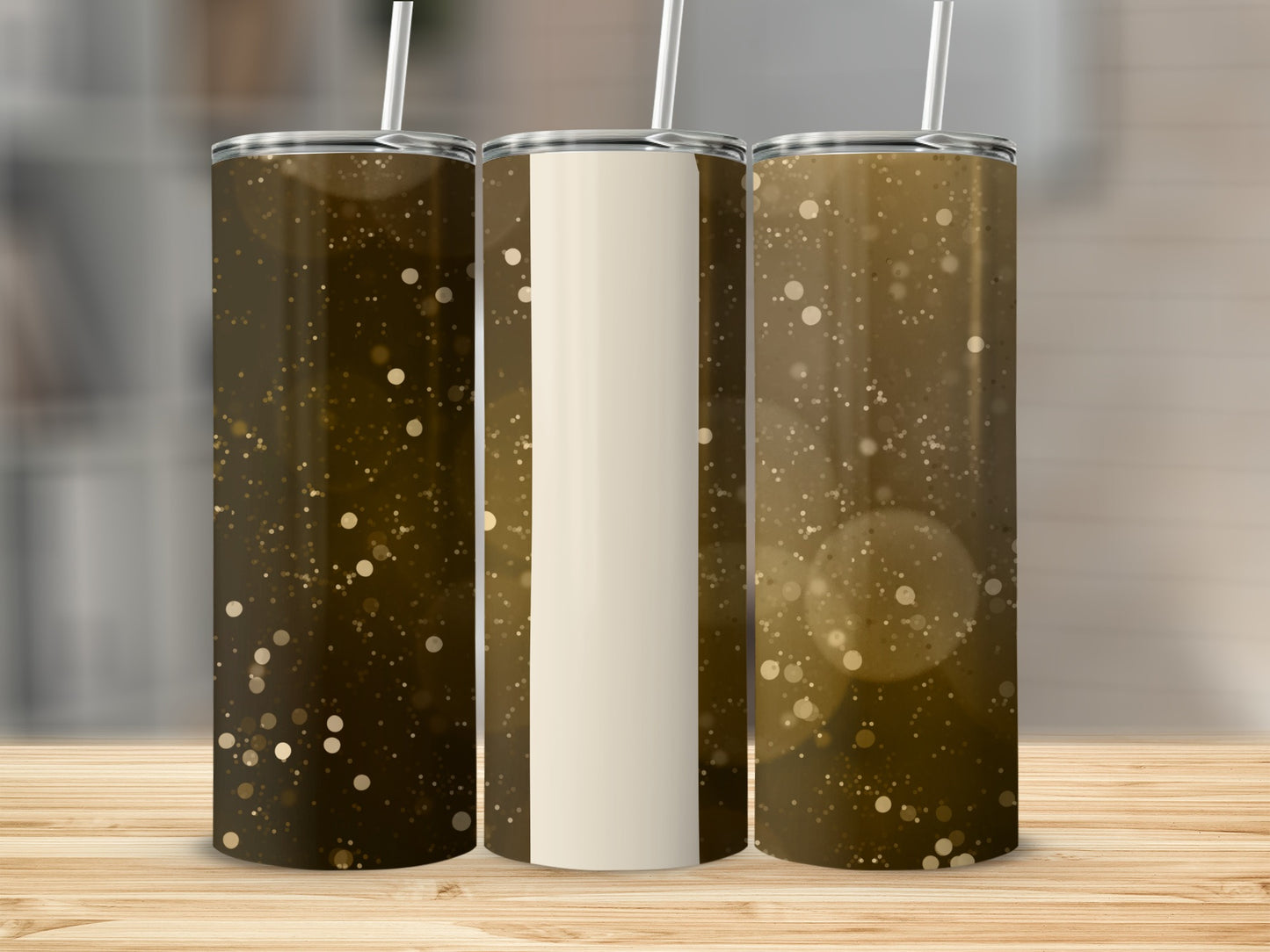 Three tumblers with a golden bokeh glitter design on a wooden surface.