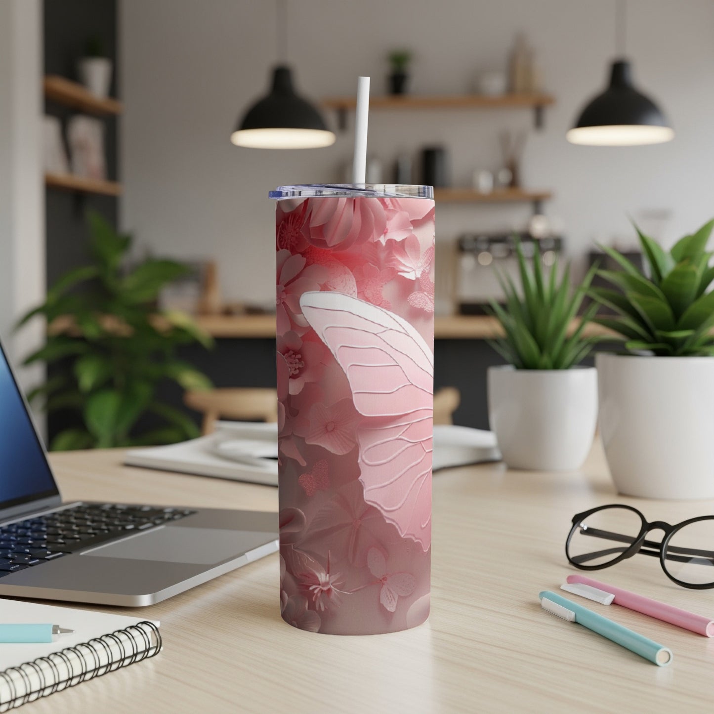 Pink butterfly wing design on a stainless steel tumbler with straw.