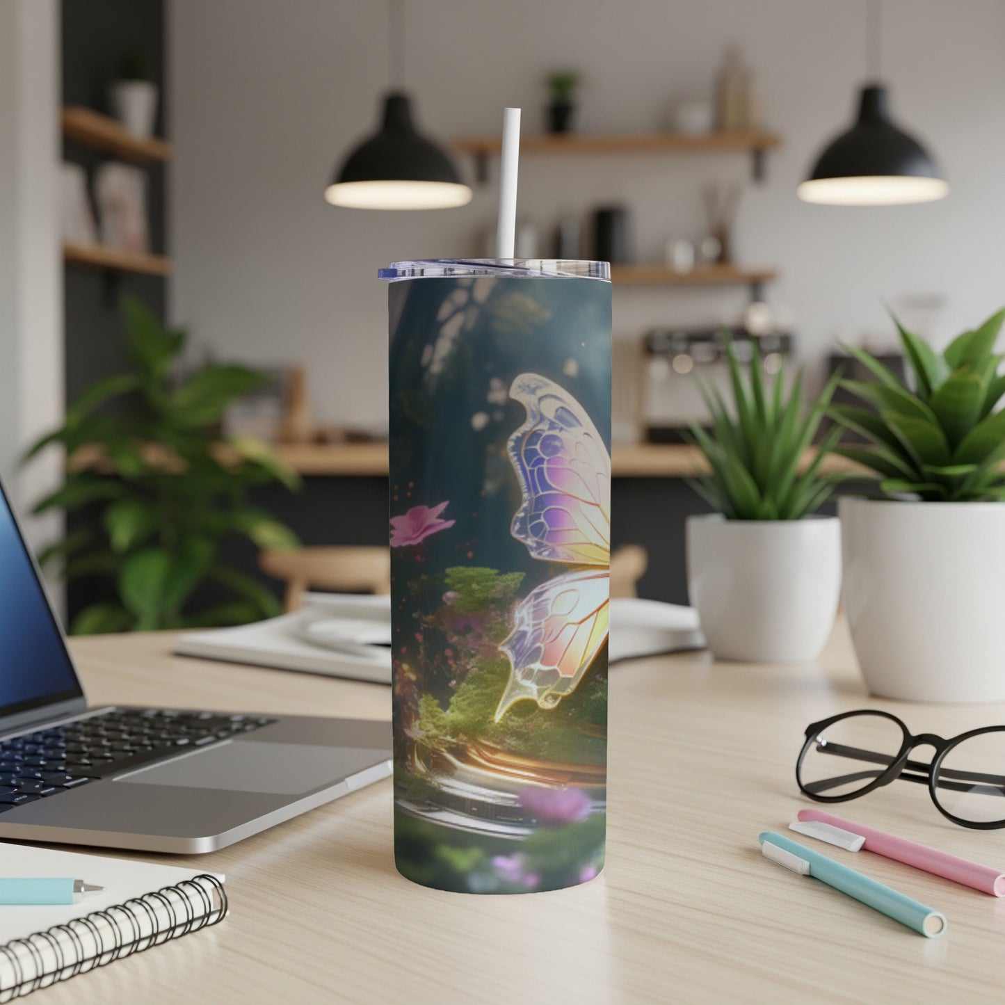 Butterfly design on a white tumbler with straw on a desk.