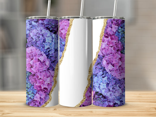 Three tumblers with floral and glitter design on a wooden surface.