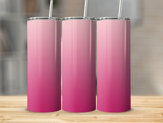 Three pink ombre gradient tumblers with straws on a wooden surface.