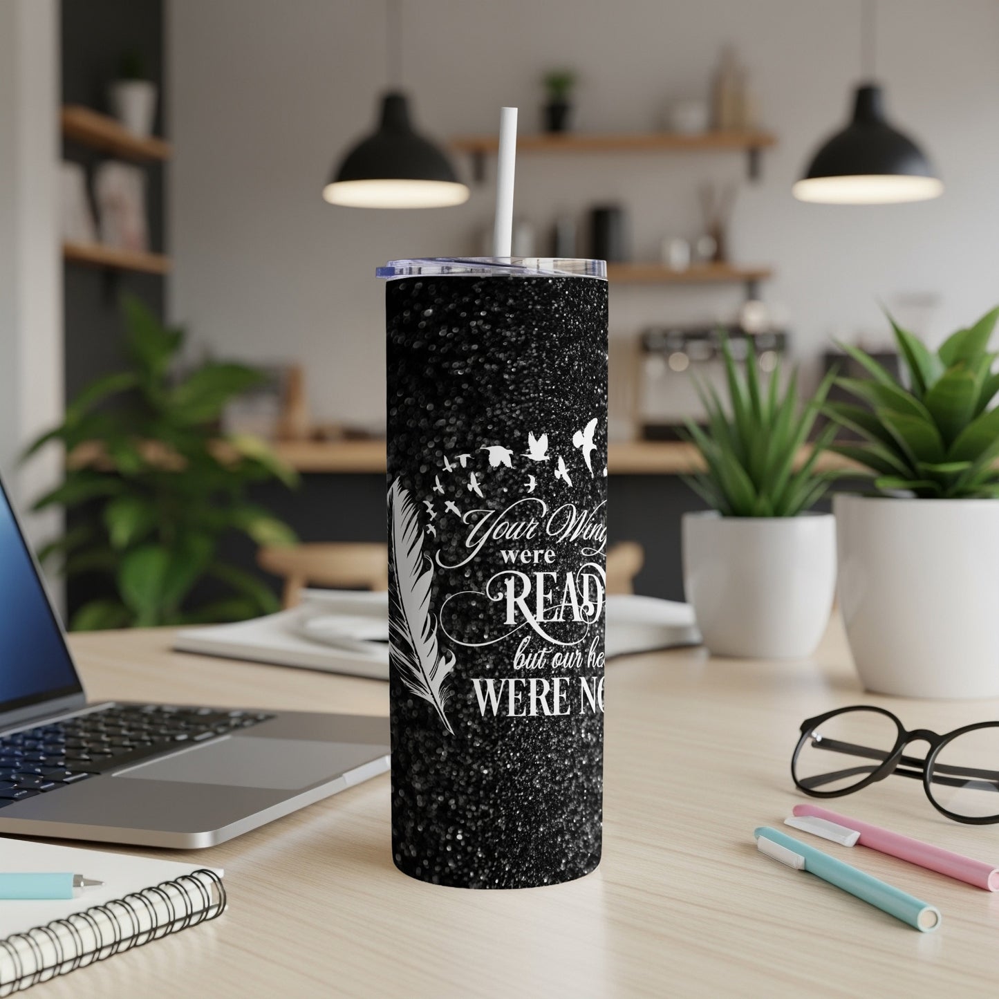Black glitter tumbler with white feather and birds design and text.