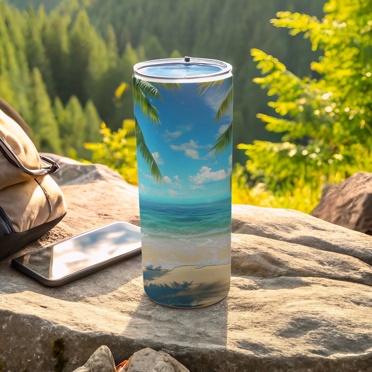 Tumbler with tropical beach scene and palm trees, resting on rocks.