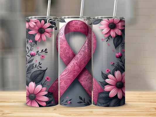 Three pink ribbon tumblers with floral designs and straws on a wooden surface.
