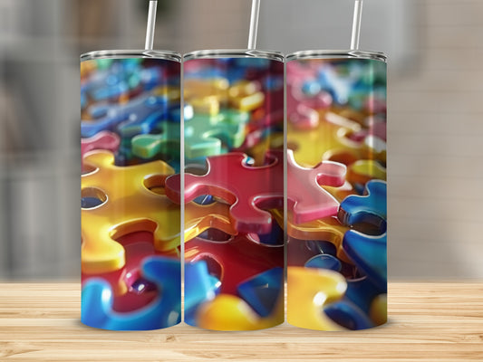 Three tumblers adorned with colorful, interlocking puzzle pieces.