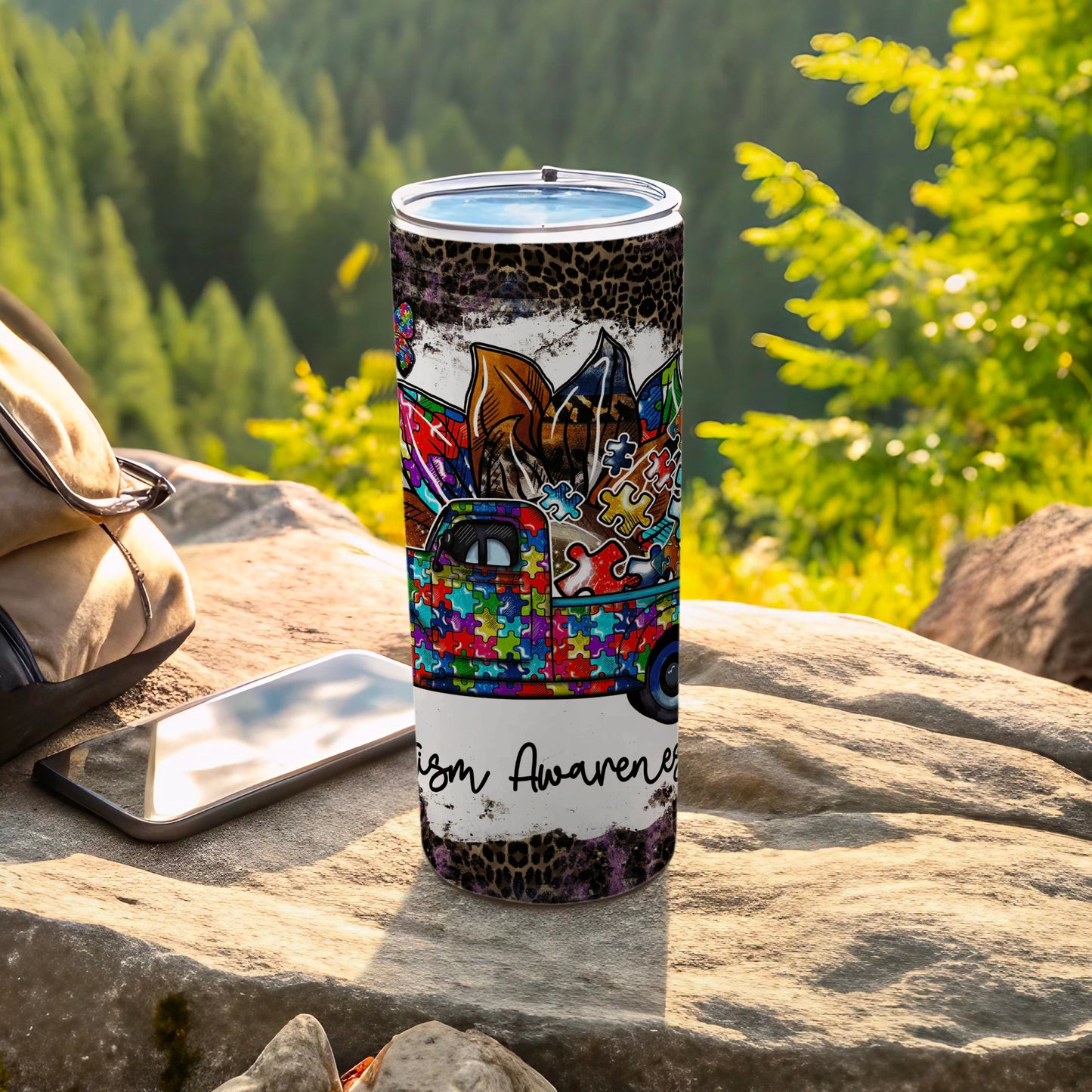 Tumbler with colorful puzzle pattern, truck graphic, and "Autism Awareness" text.