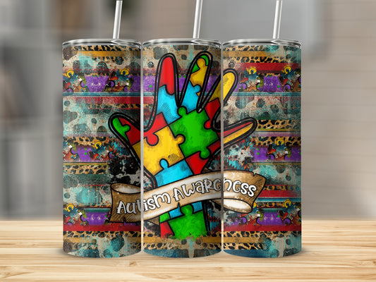 Tumbler with a colorful hand made of puzzle pieces and "Autism Awareness" ribbon.