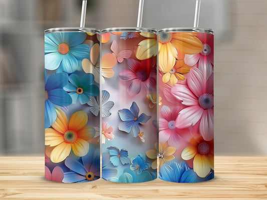 Three floral patterned tumblers with straws on a wooden surface.
