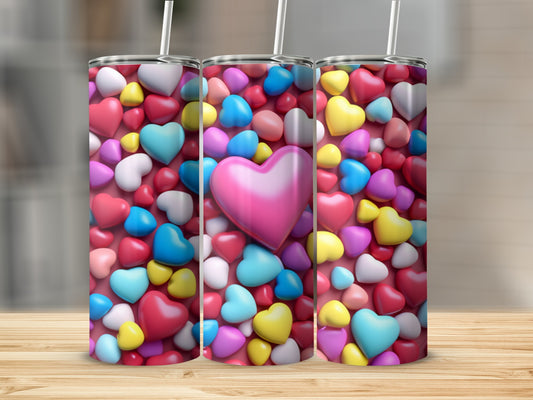 Three heart-patterned tumblers with straws on a wooden surface.