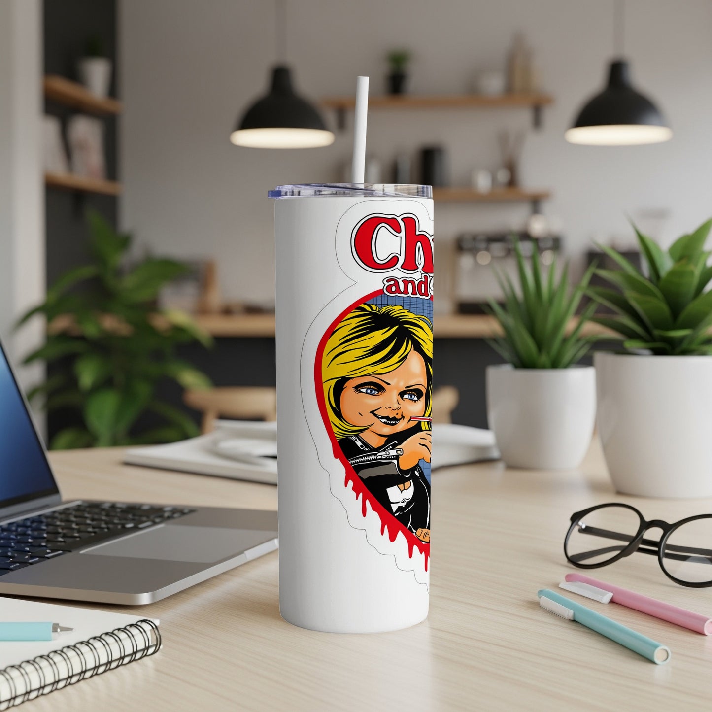 White tumbler with Chucky and Tiffany artwork and a straw.