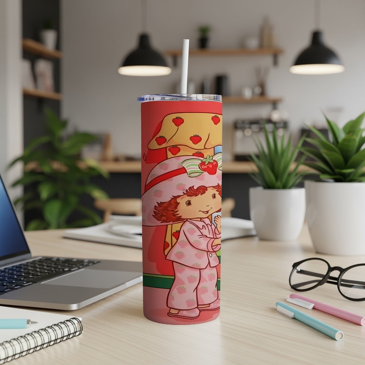 Strawberry Shortcake in pajamas holding a strawberry, on a patterned tumbler.