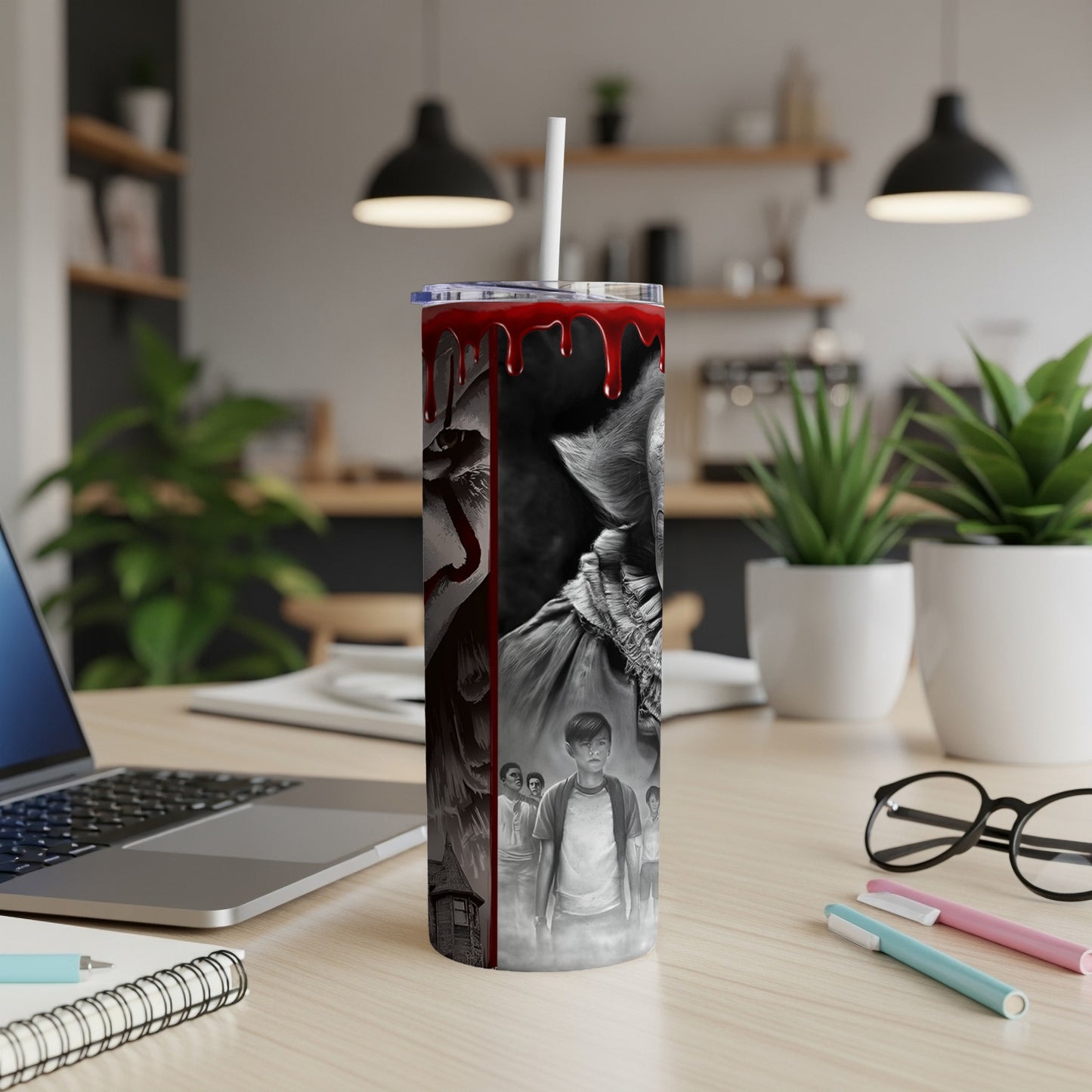 Creepy clown and child artwork on a stainless steel tumbler with a straw.