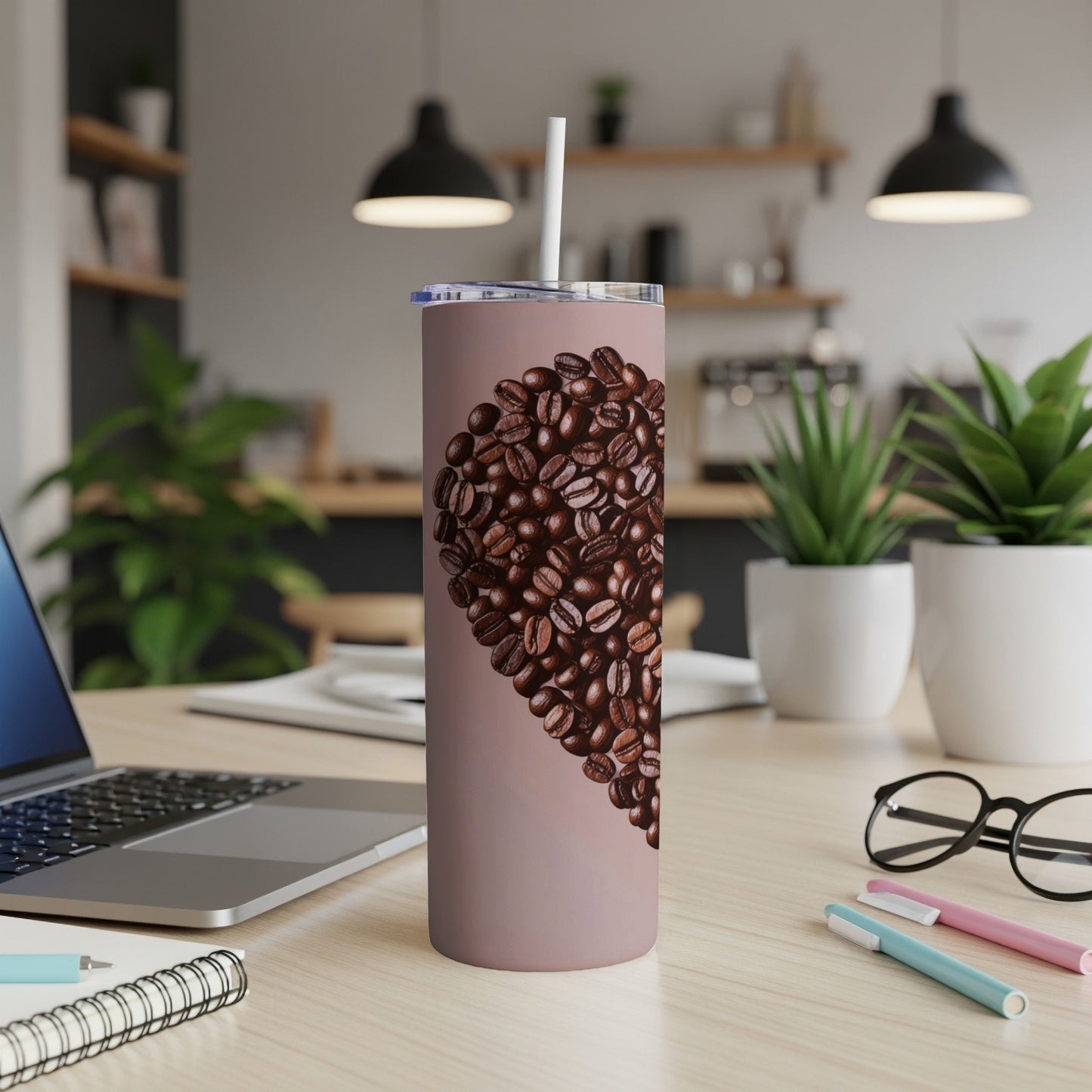 Heart-shaped coffee beans on a pink tumbler with a straw.