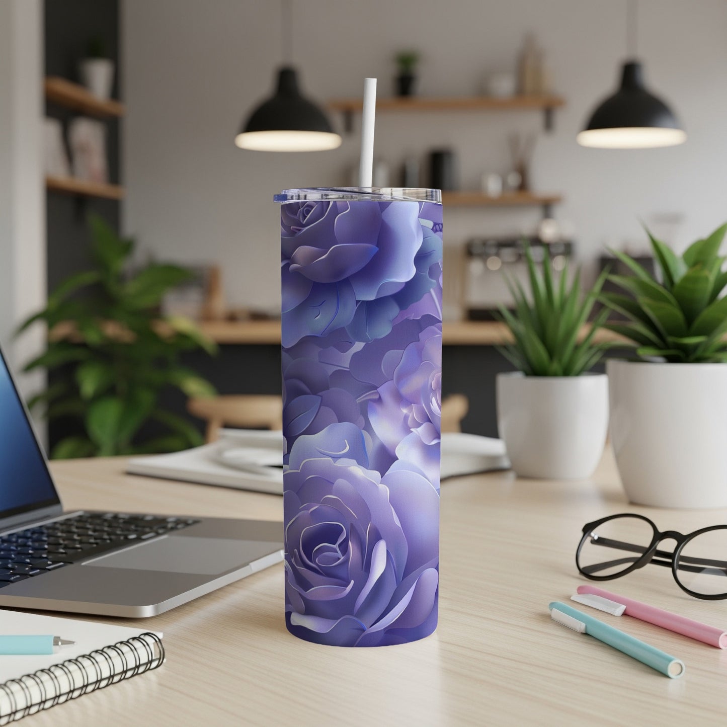 Purple floral tumbler with straw on a wooden desk.