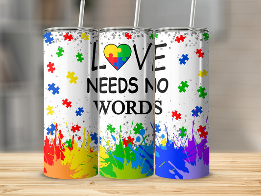 Tumbler with "Love Needs No Words" and colorful puzzle pieces.