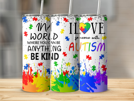 Three tumblers with colorful puzzle piece designs and autism awareness messages.