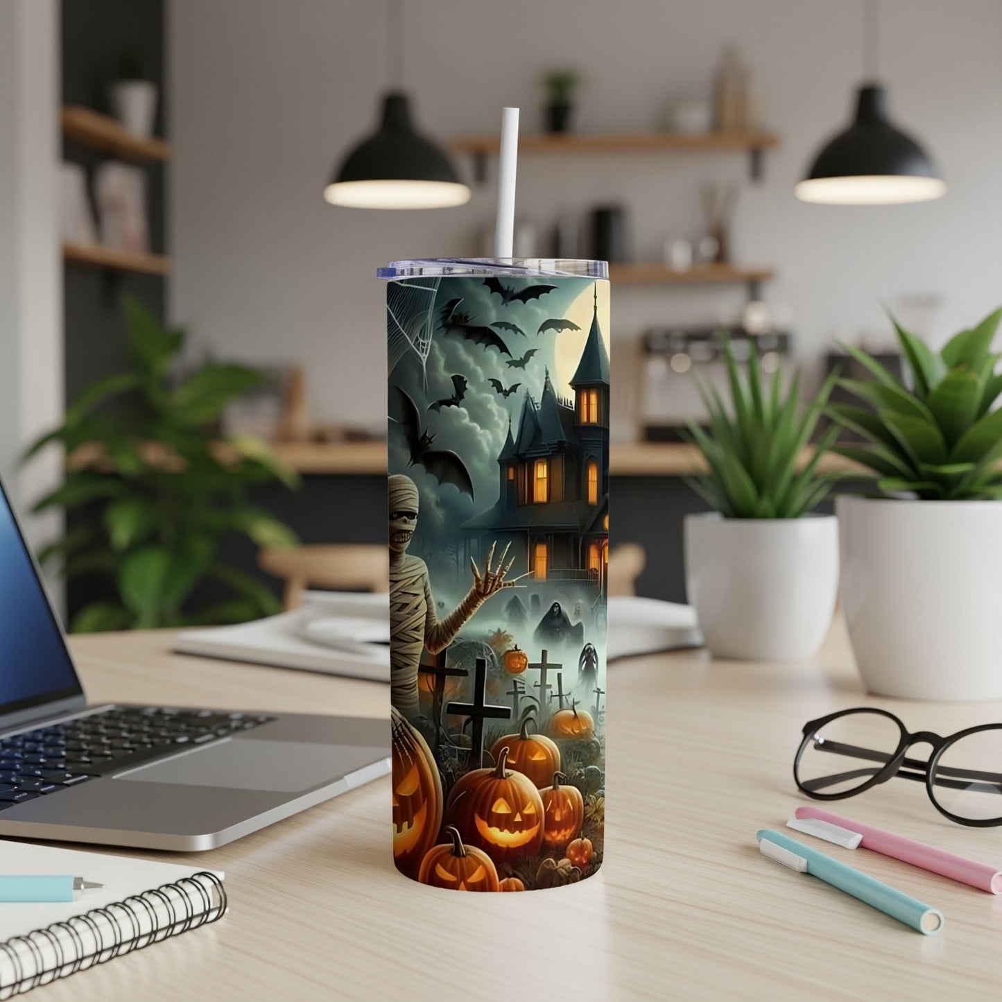 Halloween themed tumbler with mummy, bats, haunted house, pumpkins, and gravestones.