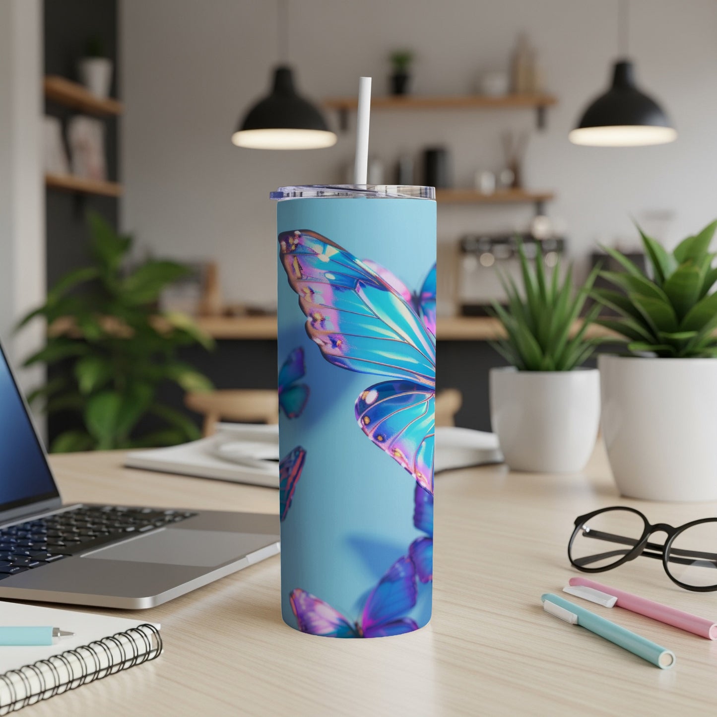 Blue tumbler with vibrant iridescent butterfly wings and a white straw.