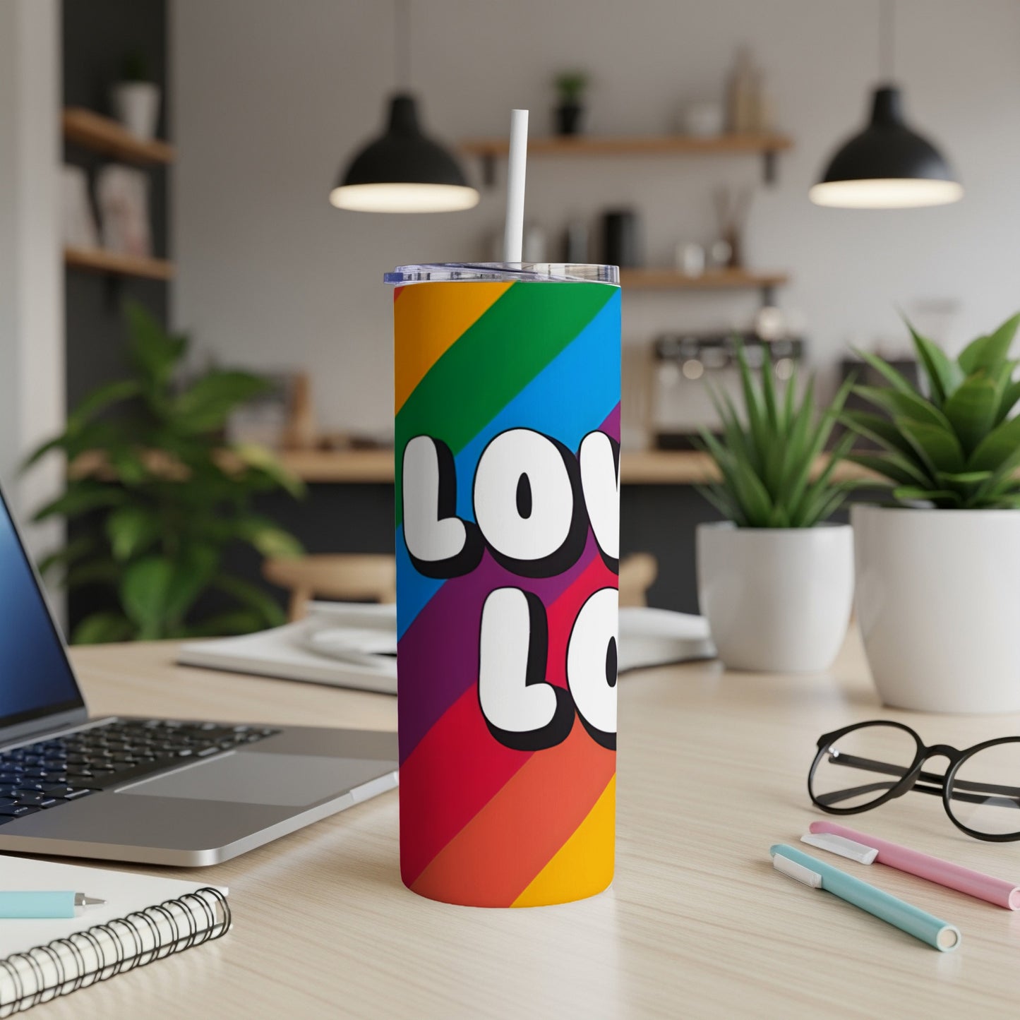 Rainbow tumbler with "LOVE LOVE" text on a desk with laptop.