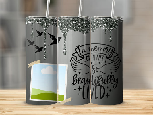 Gray tumbler with glitter drip, birds, photo placeholder, and "In memory of a life so beautifully lived" text.