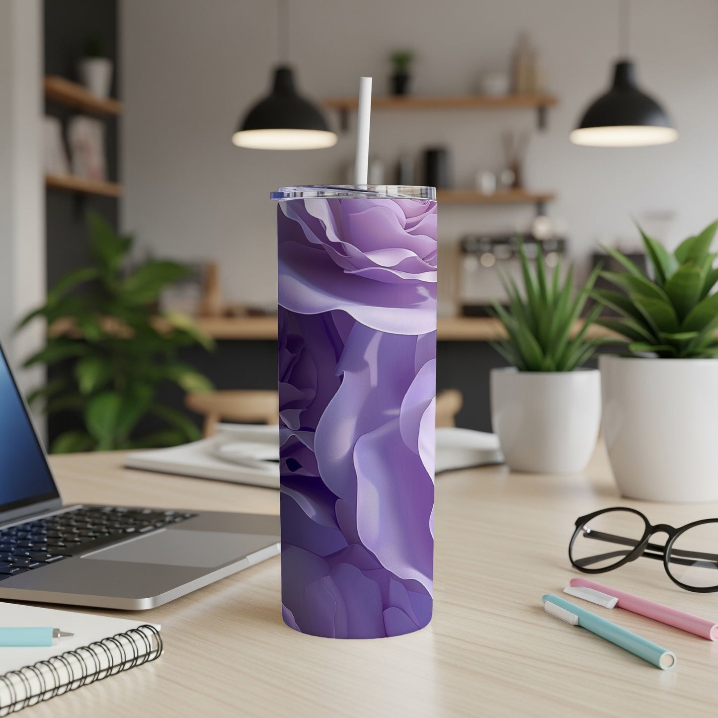 Purple floral tumbler with straw on a desk.
