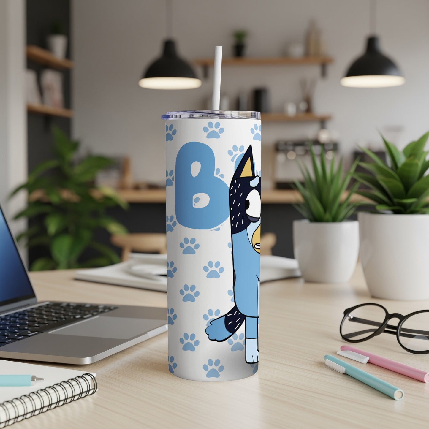 Bluey character on a blue patterned tumbler with a straw.