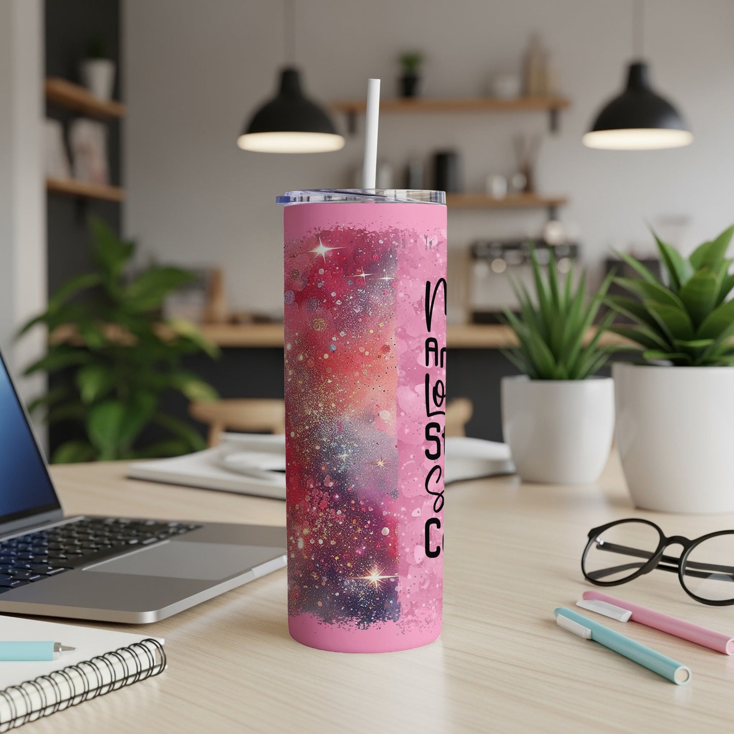 Pink glitter tumbler with "Nurse Life" text, on a desk with laptop.