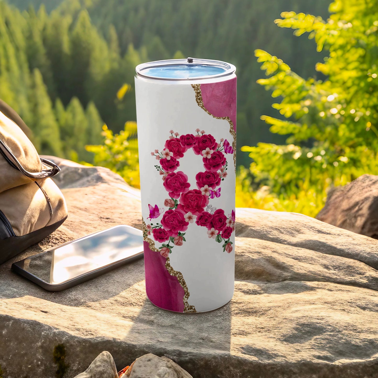 Tumbler with pink floral ribbon design and glitter accents.