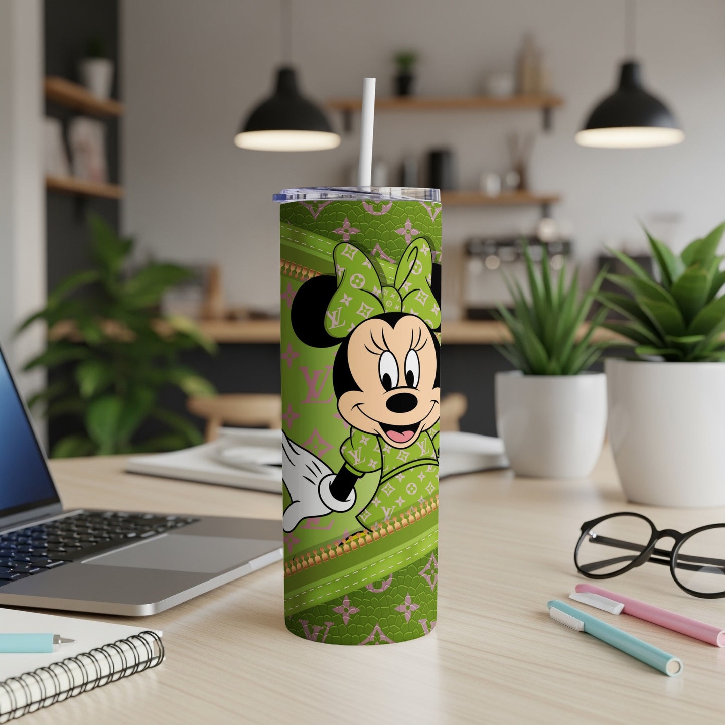 Minnie Mouse on a green patterned tumbler with a white straw.