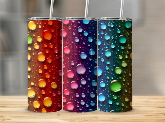 Three tumblers with colorful water drop designs and straws.