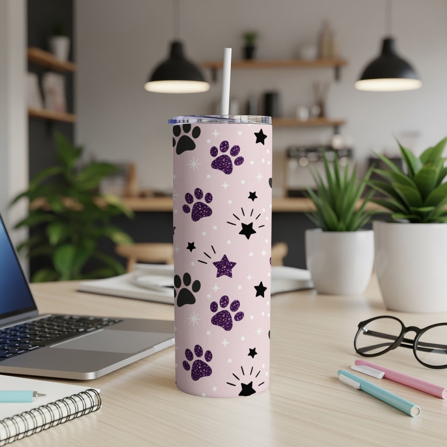 Pink tumbler with purple paw prints and white stars.