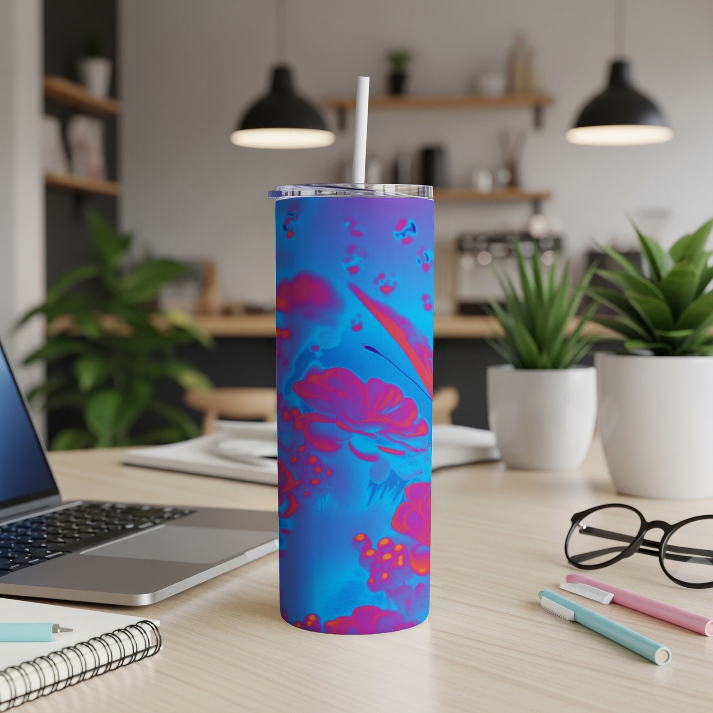 Blue and pink abstract floral pattern on a stainless steel tumbler with a straw.