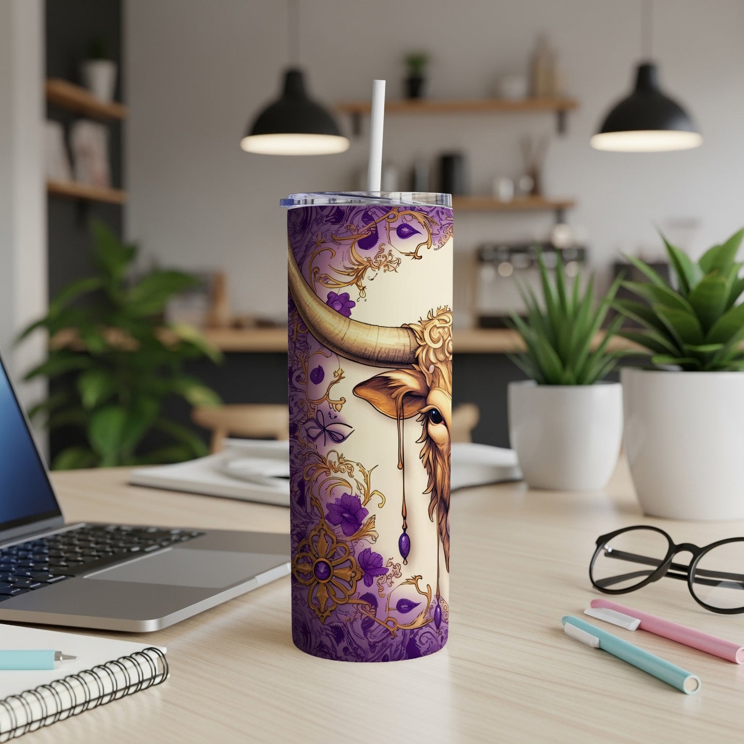 Gold bull zodiac design on a purple patterned tumbler with a straw.