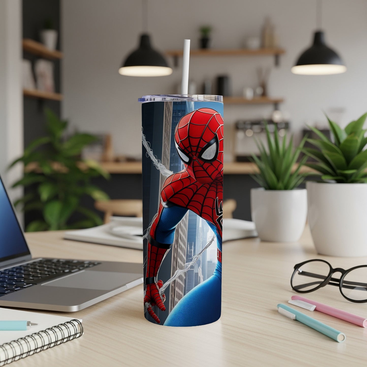 Spider-Man tumbler with cityscape background on desk.