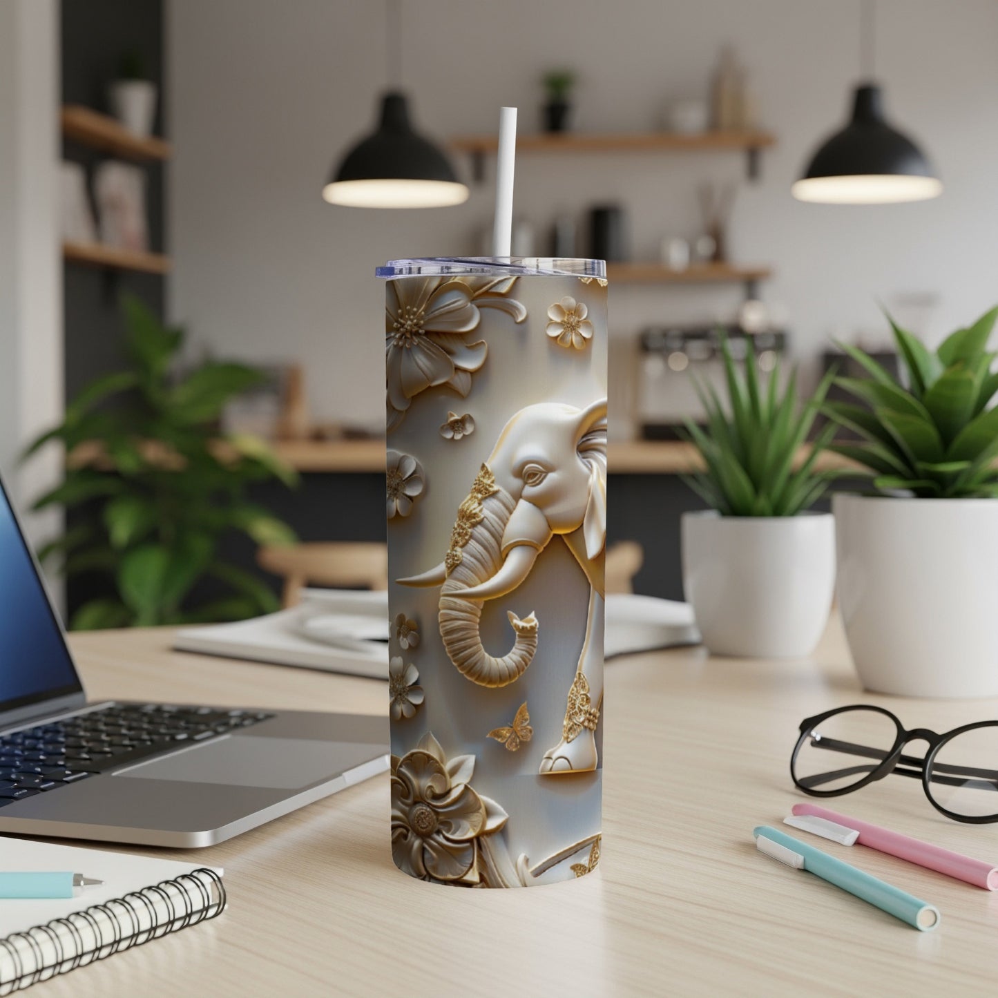 Gold elephant with floral and butterfly embellishments on a white tumbler.