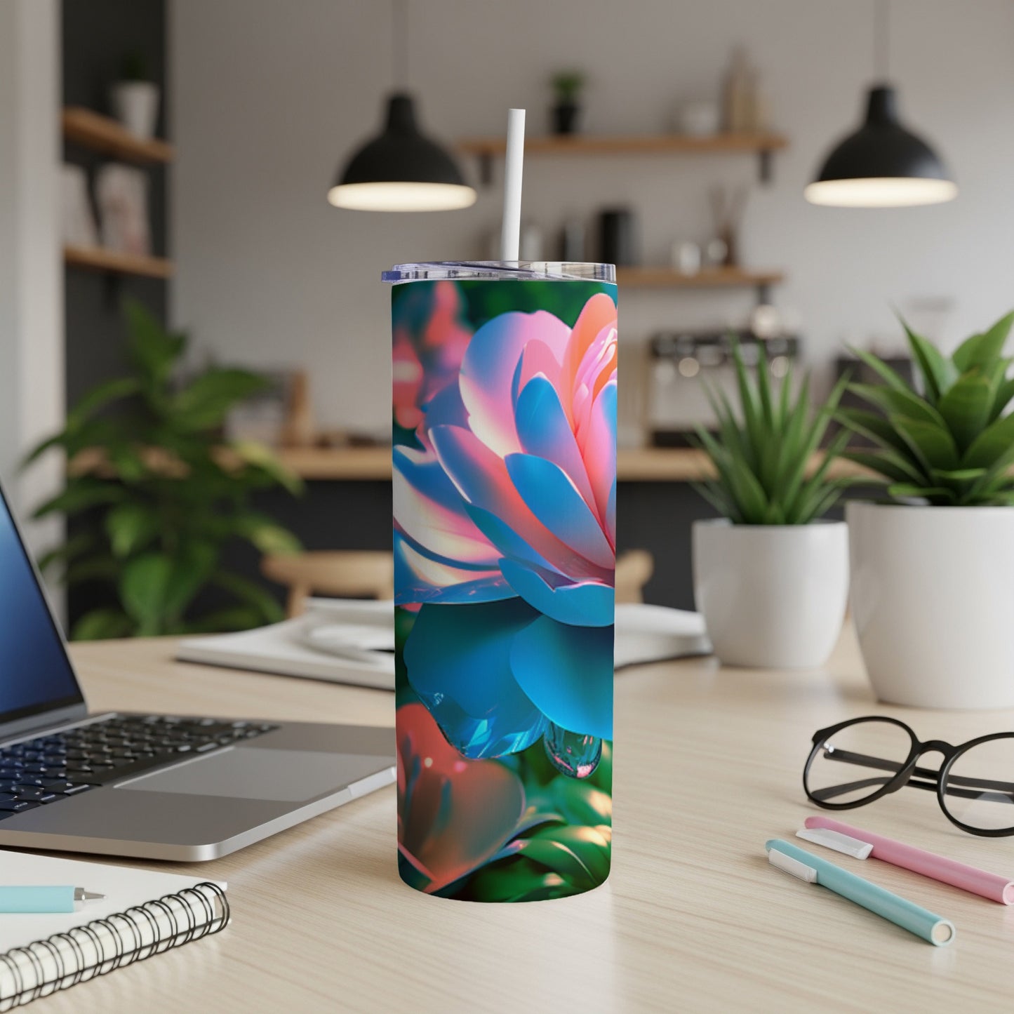 Tumbler with vibrant pink and blue floral design on a desk.