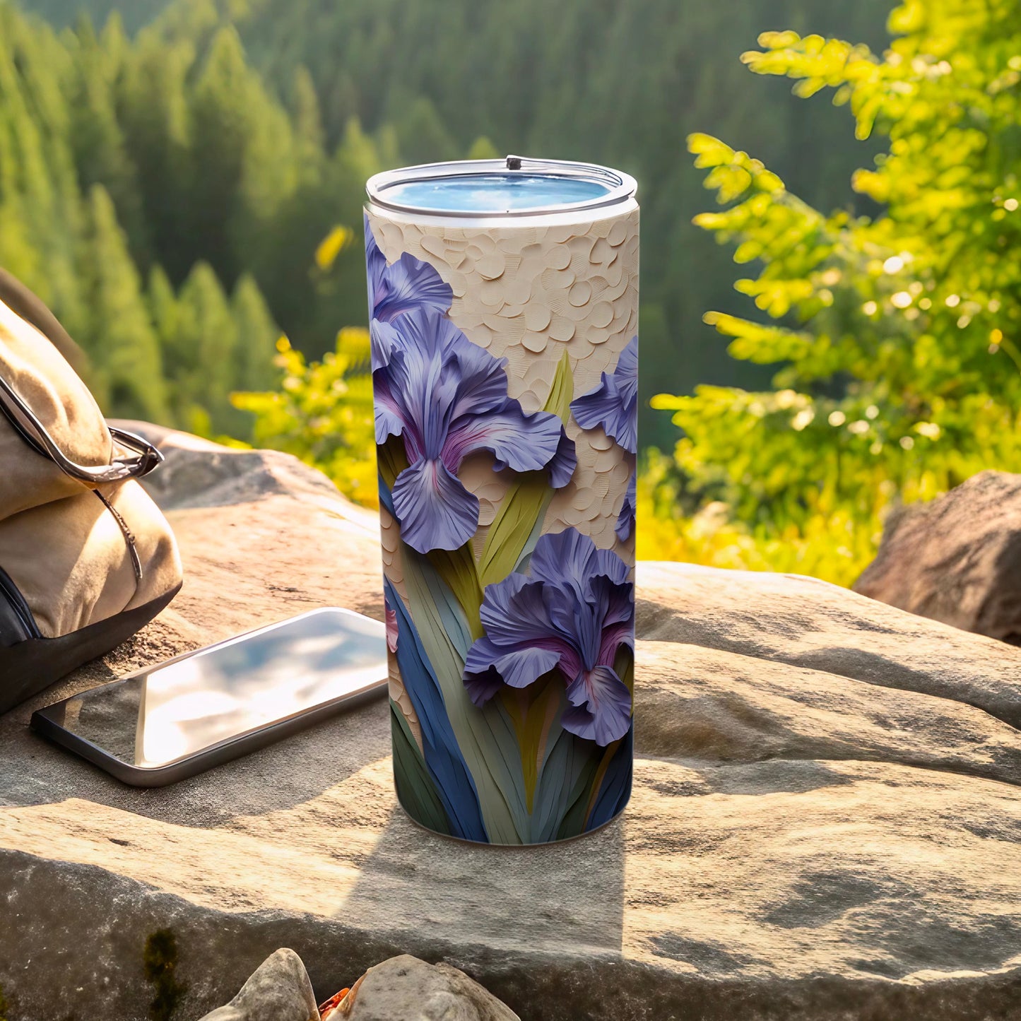 Purple iris flowers on a textured cylindrical tumbler with a blurred forest background.