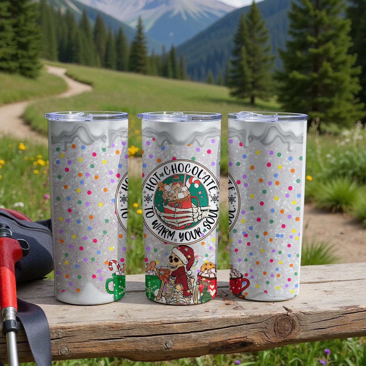Three tumblers with hot chocolate theme, confetti, and winter design.